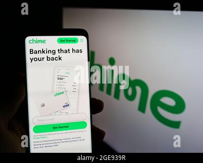 Persona che tiene lo smartphone con il sito web della società FinTech statunitense Chime Financial Inc. Sullo schermo di fronte al logo. Concentrarsi sul centro del display del telefono. Foto Stock