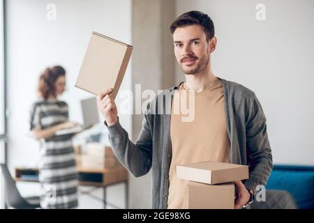 Il lavoratore del negozio del Internet che mostra la merce imballata preparata per la spedizione Foto Stock