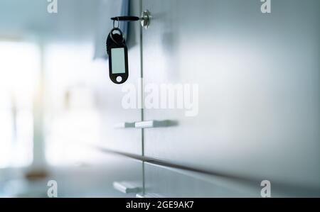 Armadietto con chiave e etichetta chiave vuota in ufficio. Serratura per armadi con chiave per sistemi di sicurezza e sicurezza nelle strutture pubbliche. Fissare il sistema di bloccaggio Foto Stock