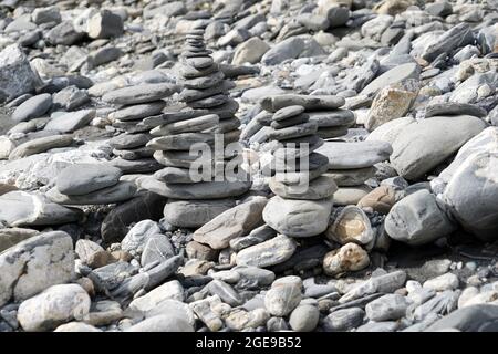 Torri in pietra o cairns in pietra. Si trovano sulla riva rocciosa del Reno in Svizzera. Foto Stock