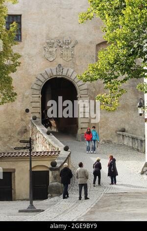 CESKY KRUMLOV, REPUBBLICA CECA - 23 settembre 2014: L'ingresso ad arco del Castello di Stato di Cesky Krumlov con due stemmi sopra e la gente che cammina Foto Stock