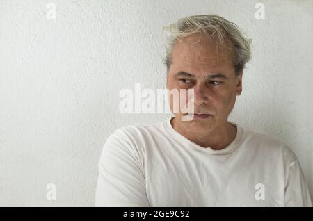 ritratto di uomo maturo con capelli grigi in camicia bianca su sfondo bianco Foto Stock