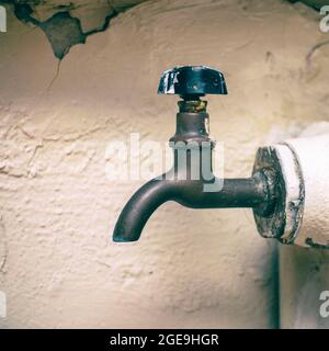 Rubinetto per scaricare l'acqua su un vecchio riscaldamento a vapore in ghisa batteria Foto Stock
