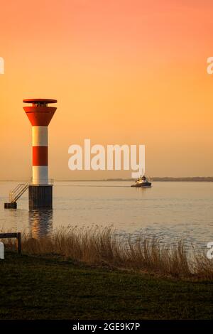 Torg Boat sull'Elba ricer passando dal faro di Stadersand al tramonto Foto Stock