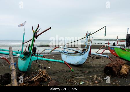 Outrigger barche da pesca (Jukungs) ormeggiate sulla spiaggia vicino Pemuteran, costa nord-occidentale di Bali, Indonesia. Foto Stock