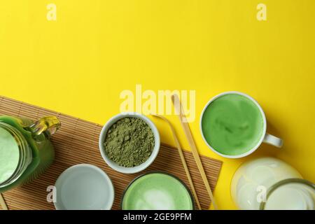 Matcha latte e accessori per la realizzazione su sfondo giallo Foto Stock