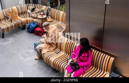 Passeggeri nell'area d'attesa alla stazione di Kings Cross a Londra in Inghilterra. Foto Stock