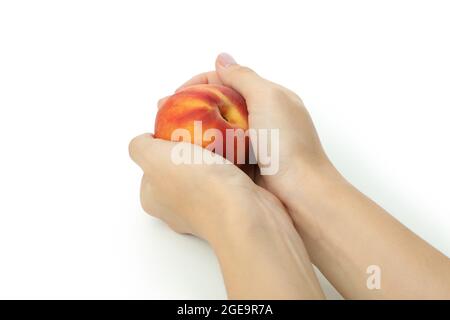 Le mani femminili tengono frutta di pesca, isolata su sfondo bianco Foto Stock
