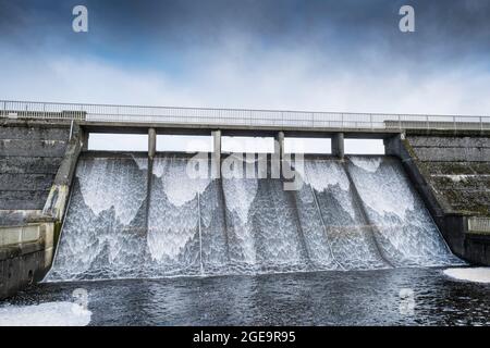L'acqua che scorre lungo il canale di troppopieno del bacino idrico di Crowdy a Bodmin Moor in Cornovaglia. Foto Stock