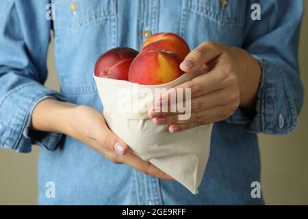 La ragazza tiene la borsa con frutti di pesca maturi Foto Stock