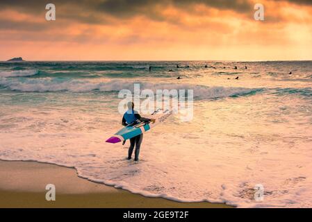 Membro del Newquay Surf Lifesaving Club durante una sessione di allenamento su Fistral Beach a Newquay in Cornovaglia. Foto Stock