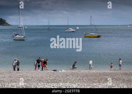 Barche a vela ormeggiate nel fiume Helford e turisti in piedi sulla spiaggia di Trebah Gardens a Polgwidden Cove in Cornovaglia. Foto Stock