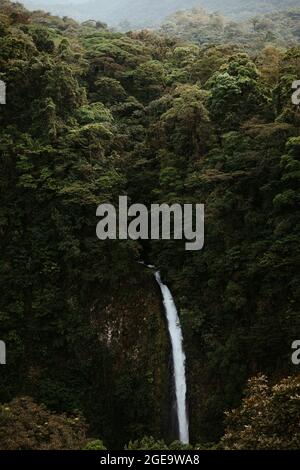 Da sopra pittoresco paesaggio di cascata che cade da ripida roccia circondata da lussureggiante vegetazione tropicale in Alajuela provincia di Costa Ric Foto Stock