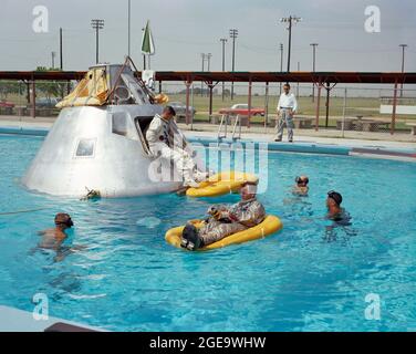 (Giugno 1966)--- i membri del primo equipaggio annunciati dalla National Aeronautics and Space Administration (NASA) per il primo volo spaziale Apollo 1 pratica le procedure di uscita dell'acqua in una piscina presso la base dell'aeronautica di Ellington (EAFB), Houston, Texas. L'astronauta Edward H. White II fa da zattera in primo piano. L'astronauta Roger B. Chaffee si trova nella botola del modello a piastra del veicolo spaziale. L'astronauta Virgil I. Grissom, terzo membro dell'equipaggio, attende all'interno del veicolo spaziale. Foto Stock