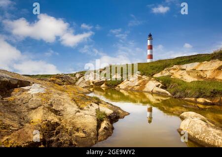 Faro di TARBAT Ness riflesso in una piscina di roccia vicino alla riva. Foto Stock