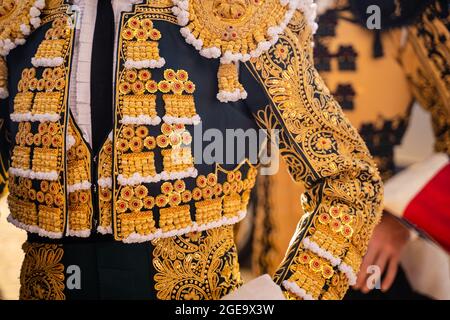 Coltivare i bullfighter irriconoscibili in costume tradizionale decorato con ricami in preparazione per la festa della corrida Foto Stock