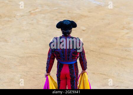 Vista posteriore di irriconoscibile toreador maschile in costume tradizionale decorato con ricami in preparazione per la festa della corrida Foto Stock