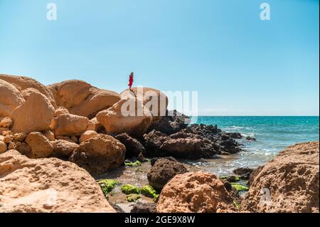Angolo elevato di prodotto femmina non riconoscibile con coppa di potenza piena di banane fresche e fette pitaya con frullato e mirtilli Foto Stock