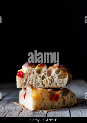 Primo piano di un pezzo di focaccia di pomodoro fresco con rosmarino Foto Stock