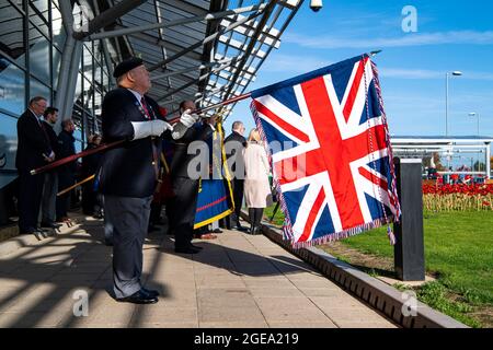 Un portatore di bandiera di un Veterano militare è all'attenzione della domenica della memoria che porta la bandiera dell'Unione. Foto Stock