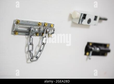 Tre serrature di sicurezza per uso domestico visualizzate su una parete bianca Foto Stock