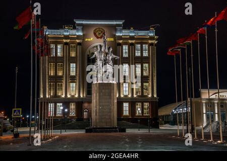 Una famosa statua di operai di epoca sovietica che sollevano il martello e la falce è fiancheggiata da file di bandiere in un museo dei veterani a Ekaterinburg, in Russia. Foto Stock