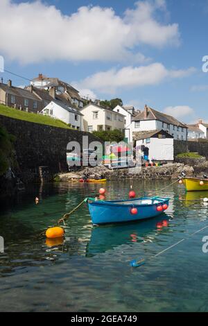 COVERACK, CORNOVAGLIA, REGNO UNITO - 1 LUGLIO 2021. Il pittoresco porto e villaggio di Coverack in Cornovaglia con piccole barche da pesca ormeggiate su un oce turchese Foto Stock