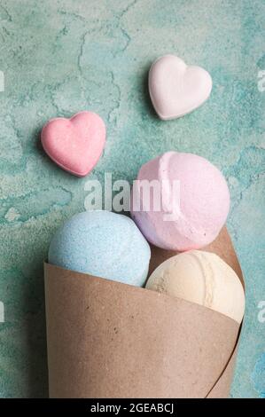 Bombe da bagno blu, vaniglia e fragola nel cono su fondo di cemento turchese Foto Stock