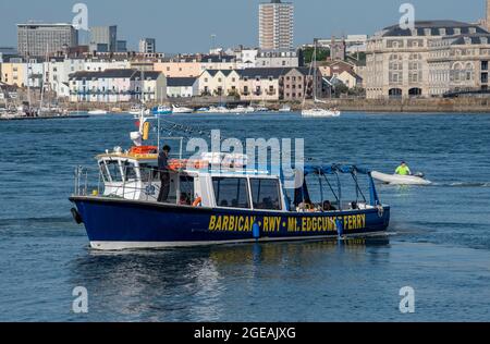 Cremyll, Cornovaglia, Inghilterra, Regno Unito. 2021. Passeggeri a bordo di un piccolo traghetto che naviga tra Plymouth e Cremyll sullo sfondo del centro di Plymouth Foto Stock