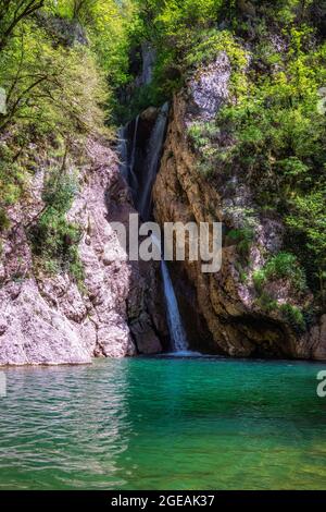 Un flusso panoramico di una cascata che cade tra una gola rocciosa. Cascate del fiume Agur nel distretto di Khosta, Russia. Viaggi, escursioni, montagna activi Foto Stock