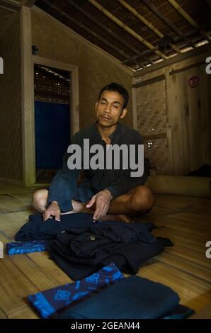 Un uomo Baduy si siede a casa sua. Baduy è una tribù tradizionale di Banten, Indonesia. Mantengono il loro stile di vita tradizionale fino ad ora. Foto Stock