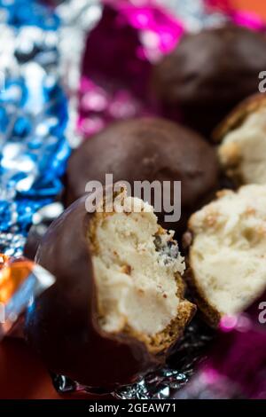 Alcuni cioccolatini e alcuni diversi involucri colorati sulla superficie arancione Foto Stock