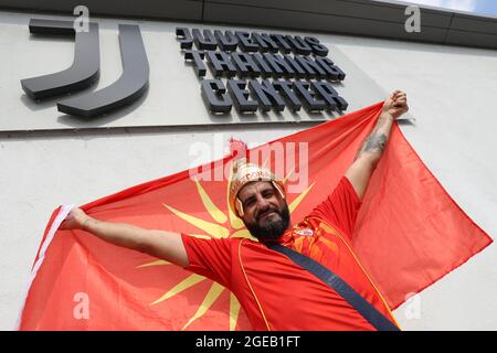 Vinovo, Italia, 18 agosto 2021. Un fan di Kamenica Sasa che indossa una camicia Macedonia regge una bandiera nazionale fuori dal centro di allenamento durante la partita della UEFA Womens Champions League al Juventus Center di Vinovo. Il credito immagine dovrebbe essere: Jonathan Moscrop / Sportimage Credit: Sportimage/Alamy Live News Foto Stock