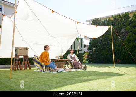 Amici giapponesi che hanno una festa in giardino Foto Stock