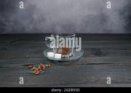 ciambella, tazza di caffè fumante con latte art e chicchi di caffè sul  tappetino di tela su un tavolo in legno e sfondo nero 2009154 Stock Photo  su Vecteezy