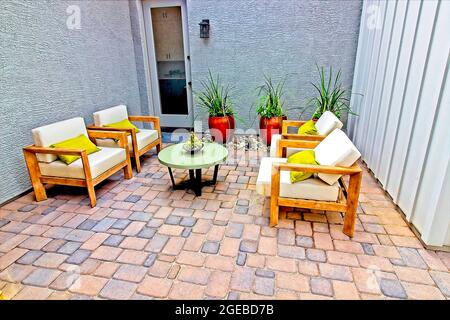 Quattro poltrone grandi sul patio del Paver anteriore Foto Stock