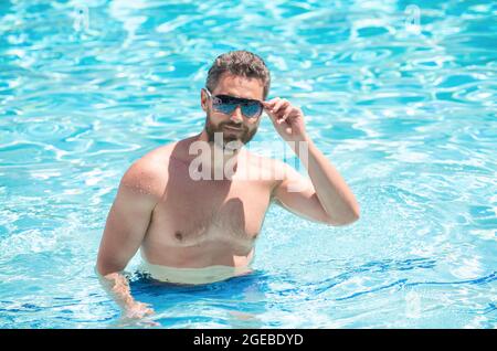 felice uomo bearded in occhiali che nuotano in piscina in estate, relax Foto Stock