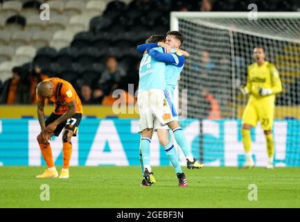 Graeme Shinnie e Max Bird di Derby County festeggiano con Josh Magennis di Hull City (a sinistra) che si è sviato dopo il fischio finale durante la partita del campionato Sky Bet allo stadio MKM, Hull. Data immagine: Mercoledì 18 agosto 2021. Foto Stock