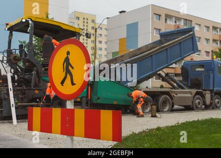 Macchina per pavimentazione stradale impilando asfalto sulla strada. Foto Stock