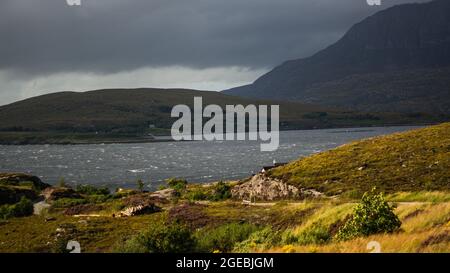 Tempo tempestoso al mare della costa schottish. Alte montagne sullo sfondo. Foto Stock