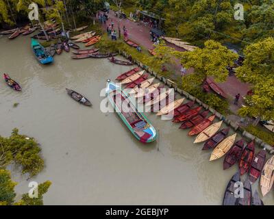 Barishal, Bangladesh, 18 agosto 2021: Veduta aerea dei costruttori di imbarcazioni fabbricano barche di legno a "Noukar Haat" (mercato delle barche) in Kuriana sotto la Swarupkathi upazila del distretto di Pirojpur. Il mercato di Noukar Haat con una lunghezza di due chilometri è noto per il commercio di diverse varietà di imbarcazioni durante la stagione monsonica. Il mercato è attivo ogni venerdì da maggio a novembre. "Panis" o "pinis", "Dingi" e "NAak Golui" sono i tipi di imbarcazioni disponibili per la vendita, costruite da artigiani locali di Muktahar, Chami, Boldia, Inderhaat, Boitha Kata, Dubi e Kathali villaggi. Credito: M Foto Stock