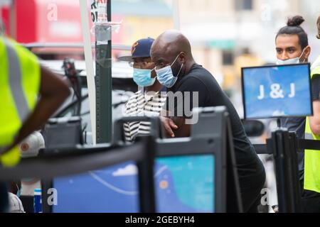 New York, Stati Uniti. 18 agosto 2021. La gente attende in fila in un centro di vaccinazione mobile COVID-19 nel quartiere Brooklyn di New York, Stati Uniti, 18 agosto 2021. Gli Stati Uniti inizieranno a somministrare i colpi di richiamo COVID-19 il mese prossimo come nuovi dati mostrano che la protezione del vaccino si indebolisce nel tempo, i funzionari superiori della salute degli Stati Uniti hanno annunciato mercoledì. Secondo il CDC, il 72.2% degli adulti americani ha ricevuto una dose di vaccino COVID-19, con il 61.8% vaccinato completamente. Credit: Michael Nagle/Xinhua/Alamy Live News Foto Stock