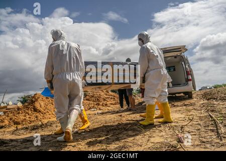 Kendari, Sulawesi sudorientale, Indonesia. 18 agosto 2021. Gli operatori sanitari portano la bara contenente il paziente covid-19 alla tomba. Il processo funerale per i pazienti Covid-19 con protocolli sanitari è effettuato dagli operatori sanitari ospedalieri a Kendari. Sebbene il numero di pazienti trattati con COVID-19 sia in diminuzione, il tasso di mortalità è costante ogni giorno. (Credit Image: © Andry Denisah/ZUMA Press Wire) Foto Stock