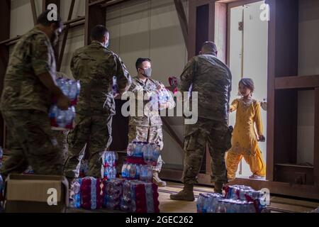 Base aerea di al Udeid, Qatar. 18 agosto 2021. I membri della 379a Ala aerea distribuiscono acqua ai cittadini afghani come parte dell'operazione Allies Refuge, il 16 agosto 2021, alla base aerea di al Udeid, Qatar. Foto di Airman prima Classe Kylie Barrow/U.S.A. Air Force/UPI Credit: UPI/Alamy Live News Foto Stock