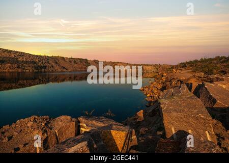 Piccolo lago circondato da rifiuti di pietra provenienti da lavori minerari Foto Stock