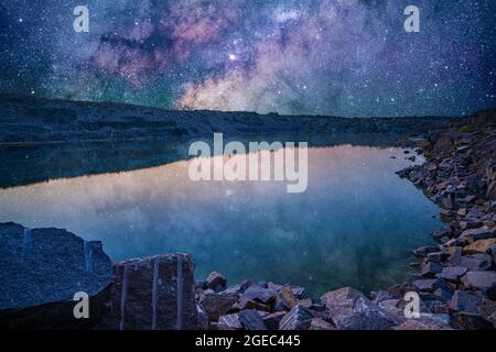 Piccolo lago circondato da rifiuti di pietra provenienti da lavori minerari Foto Stock