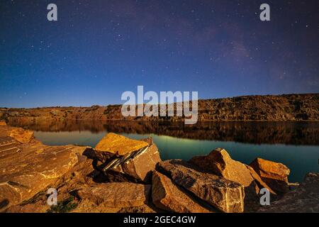 Piccolo lago circondato da rifiuti di pietra provenienti da lavori minerari Foto Stock