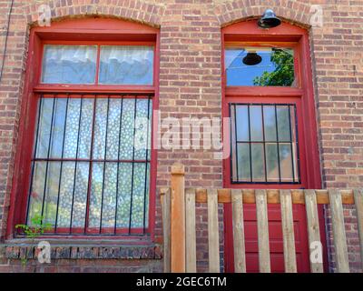Un edificio in mattoni vecchio stile con una finestra e una porta bloccate Foto Stock