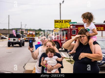 Bloomington, Stati Uniti. 18 agosto 2021. Gli onlookers su W. Morgan Street ripagano i loro omaggi durante la processione funeraria per il paramedico caduto Brandon Staley a Spencer, Indiana. Staley morì per un attacco di cuore mentre lavorava come paramedico per Owen County EMS (Emergency Medical Services). Staley aveva appena risposto a un incidente stradale e si trovava in un'ambulanza con i sopravvissuti agli incidenti che li aiutavano durante il viaggio verso un ospedale quando egli stesso si ammalò. Credit: SOPA Images Limited/Alamy Live News Foto Stock