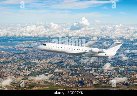 Passeggero aereo bianco vola su una grande megapopoli, città Foto Stock